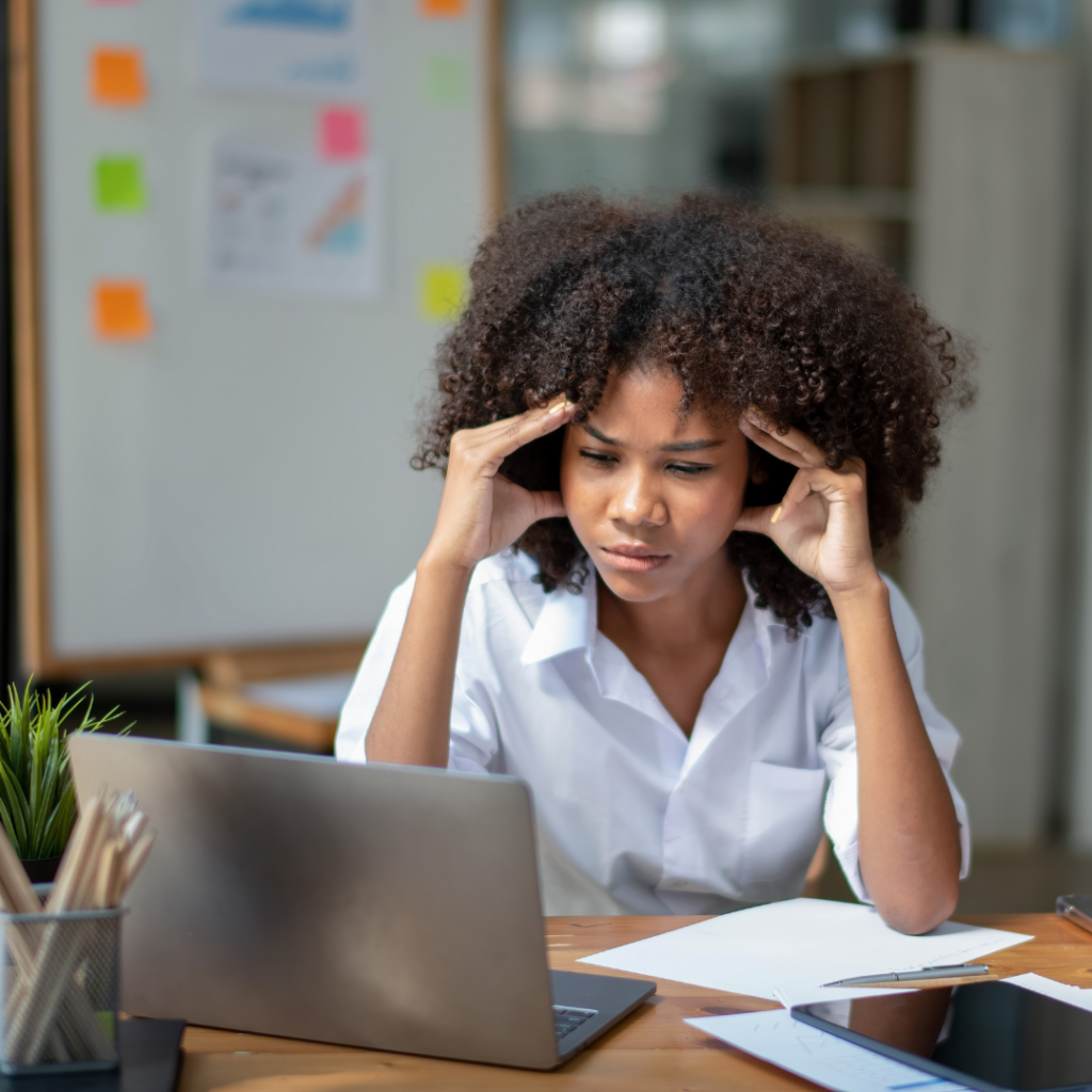 This is a picture of a woman looking stressed at work to show readers that if they are feeling the strain already? Fix your packing line and make 2026 run smoother
